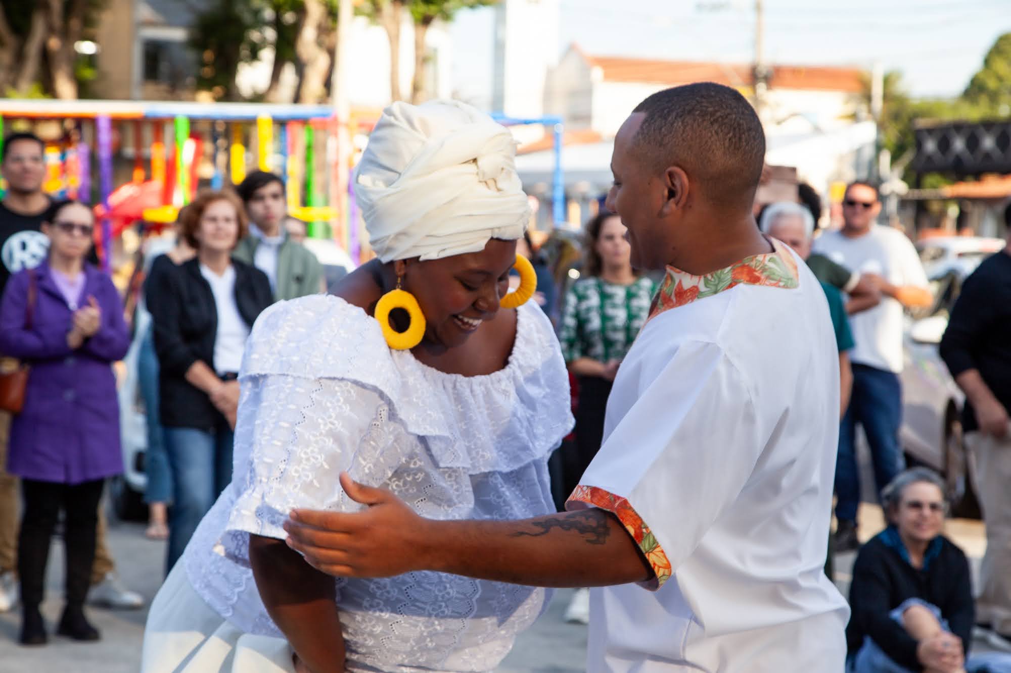 Casal em traje tradicional dançando em cortejo de rua