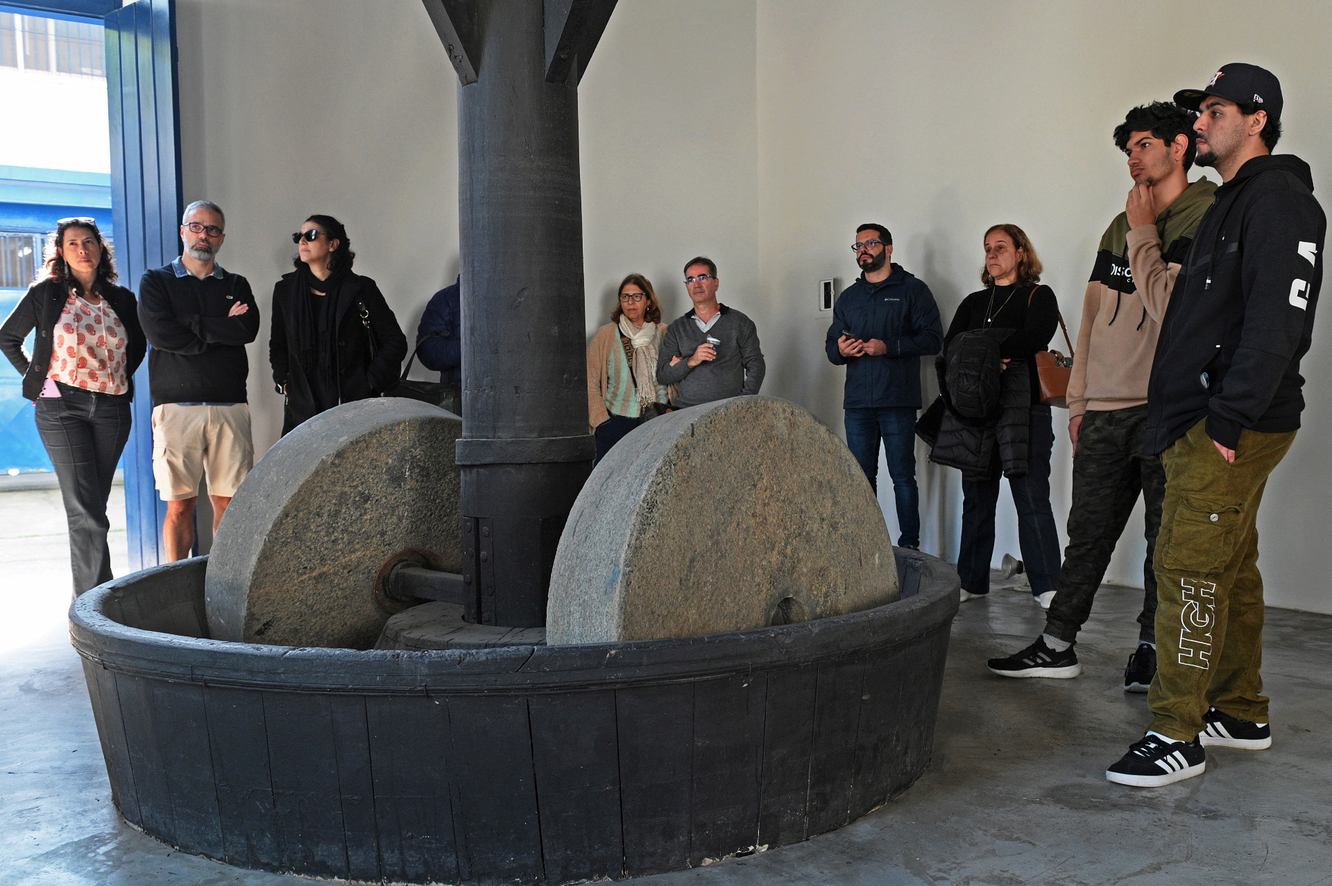 Visitantes observando roda de moenda histórica